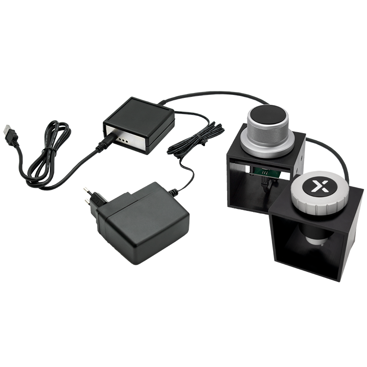 The image shows a HAPTICORE Eval Kit Combi Bundle consisting of a HAPTICORE 34-P001X1 and HAPTICORE 40-P001X1 Eval Kit as well as a HAPTICORE Control Unit Pro, including a 12 V power supply and USB-C connection cable.