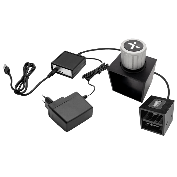 The image shows a HAPTICORE Eval Kit Combi Bundle consisting of a HAPTICORE 14-P001X1 and HAPTICORE 34-P001X3 Eval Kit as well as a HAPTICORE Control Unit Pro, including a 12 V power supply and USB-C connection cable.